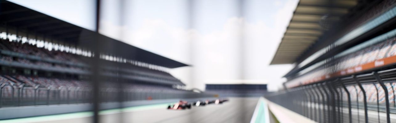 Un circuit de Formule 1 vu de côté avec des tribunes en arrière-plan et une piste incurvée au premier plan.