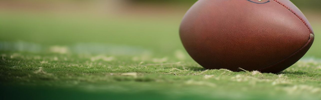 Un gros plan d'un ballon de football sur un champ herbeux.
