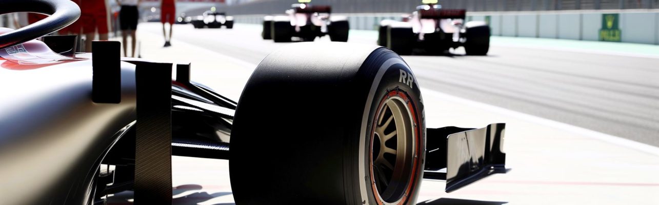 Photographie montrant de pres les roues et l'aileron arriere d'une voiture de F1 dans la voie des stands.