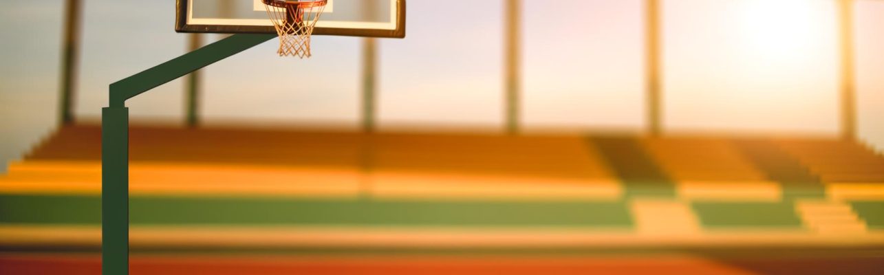Terrain de basket avec un arceau et un filet éclairés par la lumière dorée
