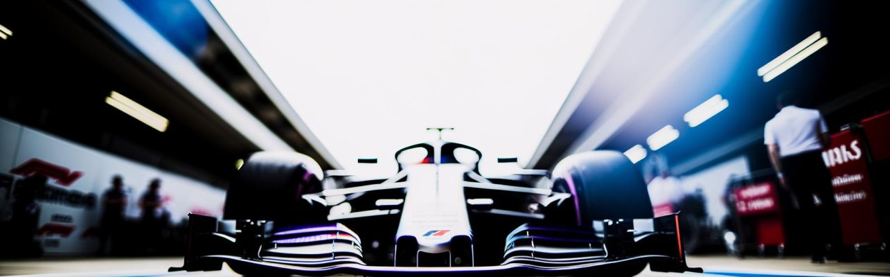 Voiture de Formule 1 sur une voie des stands avec un arrière-plan flou.